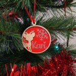 Boule de Noël sur le sapin, modèle renne, fond rouge et prénom Kari